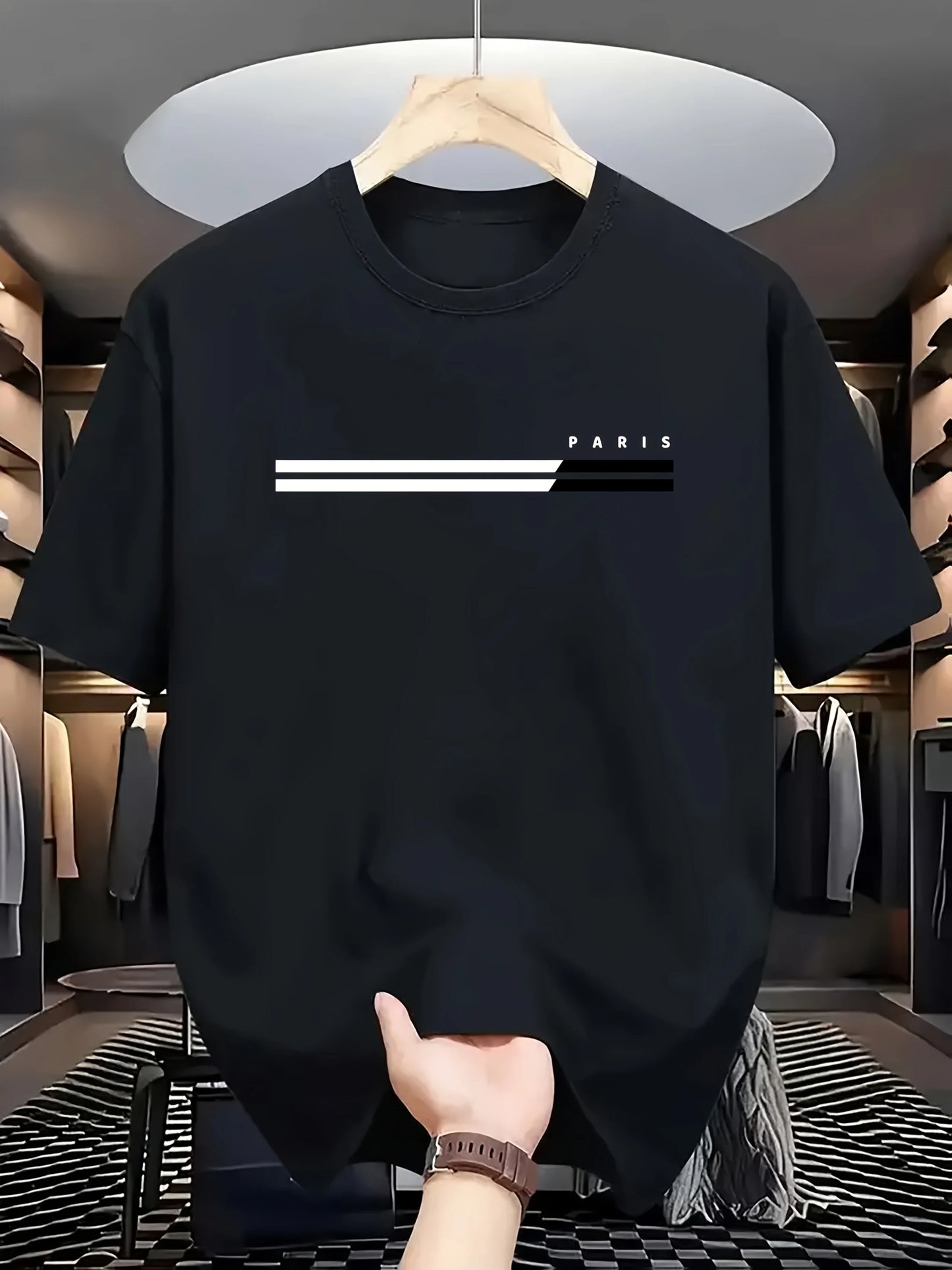 Black t-shirt with 'PARIS' design on a hanger in a clothing store.