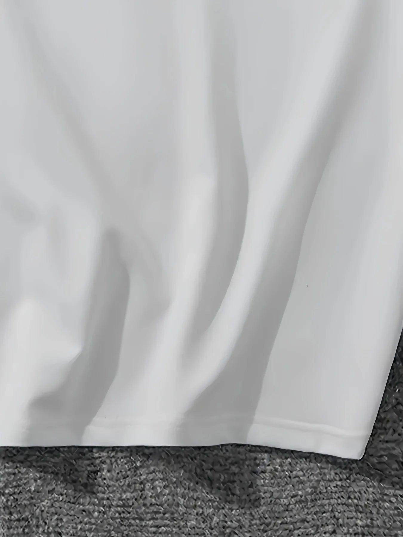 Close-up of a white fabric edge on a textured gray surface